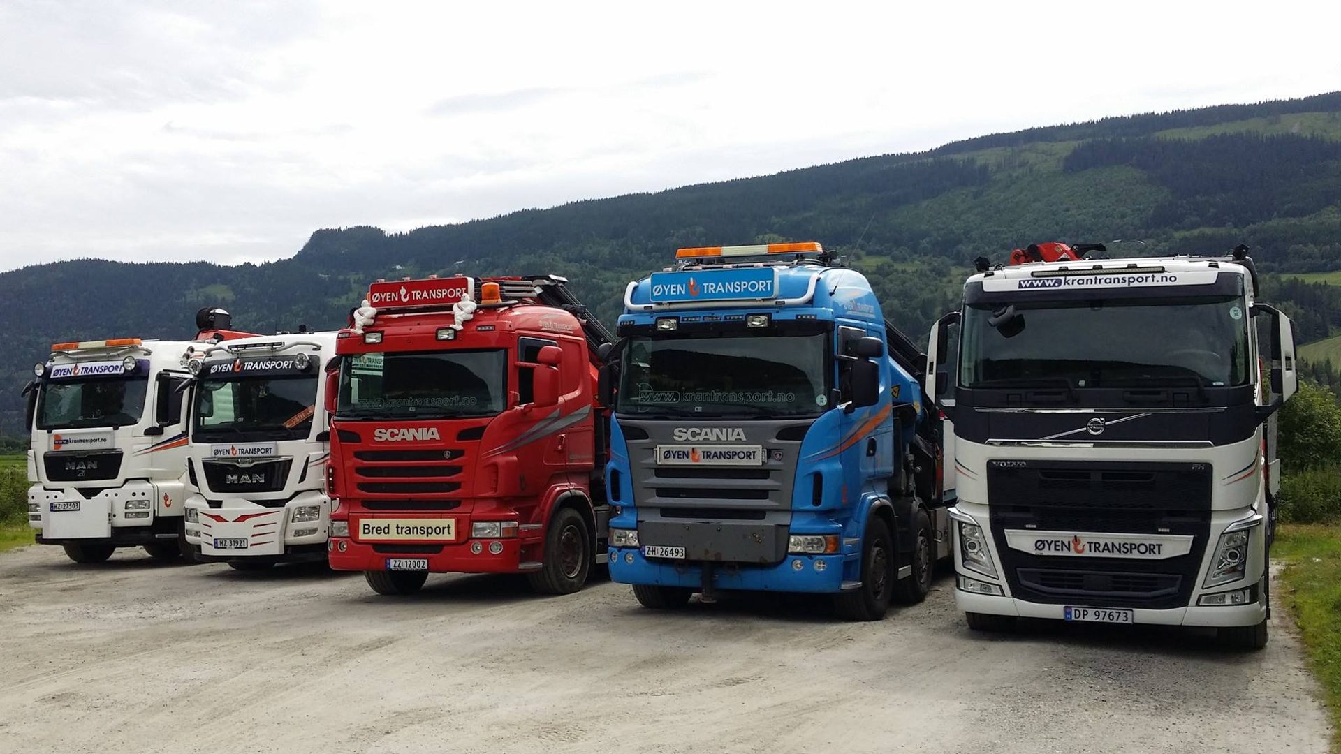 Øyen Transports fem kranbiler – MAN, Scania og Volvo – oppstilt foran lia i Gudbrandsdalen